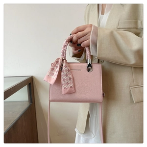 Pink lychee grain square bag with woven handle and plaid silk scarf detail shot