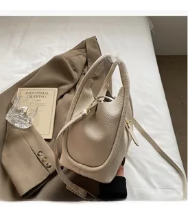 Détail du sac seau en cuir grainé crème avec fermoir métallique et poignée élégante