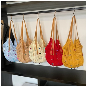 Close-up of knit tote bags in five colors featuring sequins and faux leather straps
