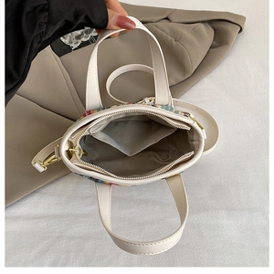 Internal view of colorful tweed beach bag showing grey lining and gold zipper detail