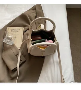 Vue intérieure du sac à main blanc cassé avec motif litchi montrant un grand espace