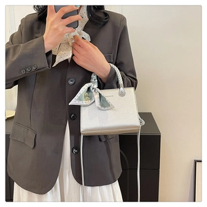 Mirror selfie showing a silver litchi grain tote bag with a woven handle and silk scarf