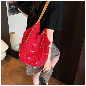 Detail of red knit tote bag with colorful sequins and brown leather shoulder strap