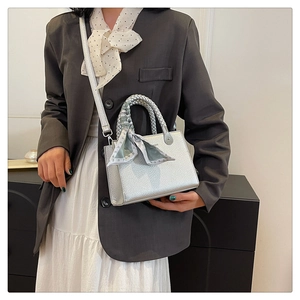 Silver lychee textured handbag with woven handle and silk scarf shown on model