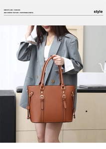 Macro shot of large brown tote bag with leather texture, metal buckles, and side tassels