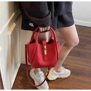Vue détaillée du sac à main en cuir grainé rouge avec boucle dorée et bandoulière