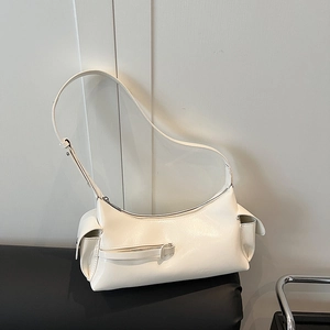 Minimalist creamy white leather baguette bag with functional utility pockets and shoulder strap