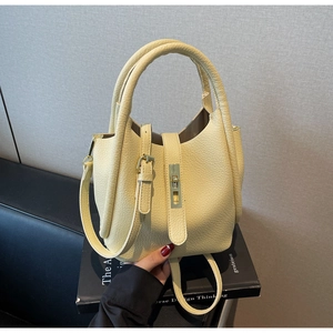 Détail du sac seau jaune crème avec texture litchi et boucle en métal doré