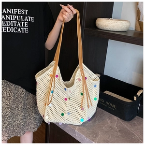 Detail of cream crochet tote bag with colorful polka dots and brown leather handles