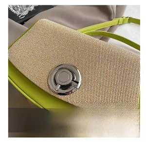 Detail view of the green leather and straw texture contrast with a round metal lock