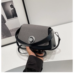 Detail of a minimalist black PU and grey tweed box bag with a silver rotary metal lock