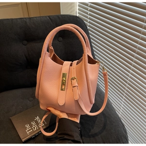 Détails du sac à main en cuir rose grainé avec fermoir doré et doubles anses
