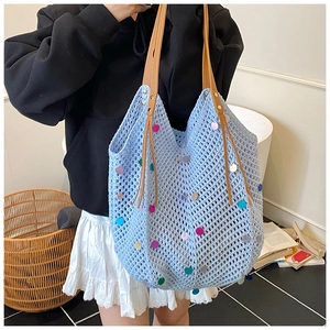 Detail of light blue crochet tote bag with colorful sequins and brown leather strap