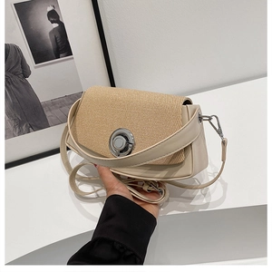 Detail of minimalist beige PU leather and straw woven crossbody bag with silver clasp