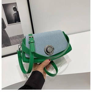 Detail of color-blocked PU shoulder bag with green strap and silver twist lock