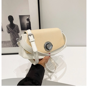Detail of a white PU leather crossbody bag featuring a woven flap and silver metal ring clasp