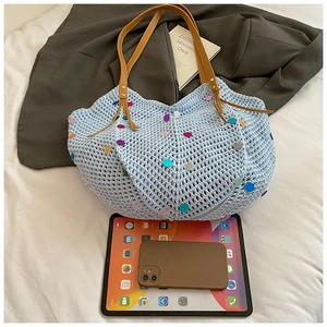 Detail view of woven knit tote bag with colorful sequins and brown faux leather straps
