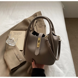 Détail du sac seau en cuir grainé avec fermoir doré et bandoulière réglable pratique