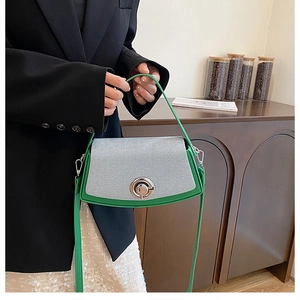 Close-up of green and textured grey flap handbag with silver metallic twist lock buckle