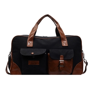 Large black canvas travel bag with brown leather contrast and adjustable shoulder strap