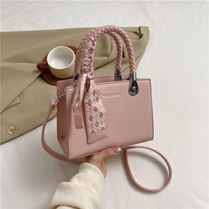 Pink lychee texture handbag with woven handles and plaid scarf in a stylish scene