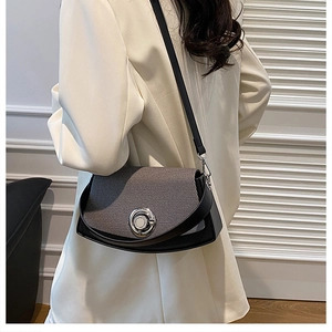 Detail of trendy PU leather crossbody bag with gray textured flap on a model