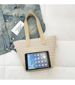 Flat lay of a beige woven tote bag with lace overlay and flat shoulder straps