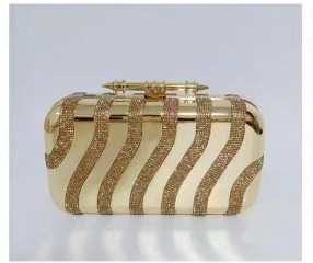 Detailed close-up of a gold acrylic evening clutch featuring wavy rhinestone stripe patterns