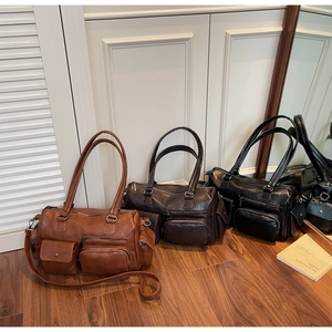 Gros plan du sac vintage multi-poches avec texture grainée douce et fermetures éclair