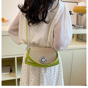 Detail of green and beige crossbody bag featuring woven texture and silver twist lock