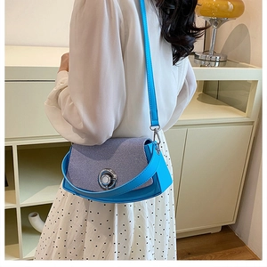 Blue crossbody box bag with silver lock shown on model for size and style reference