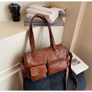 Détail du sac bandoulière en cuir PU marron avec poches zippées et texture litchi fine