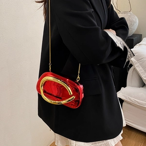Close-up of a red metallic evening clutch with a gold U-shaped handle and chain strap