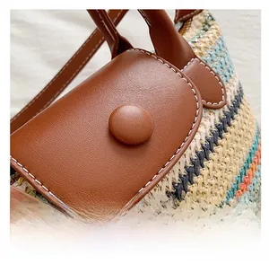 Close-up of woven straw texture and premium brown leather handle with contrast stitching