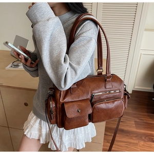 Vue latérale d'un sac cabas vintage en cuir marron avec plusieurs poches externes
