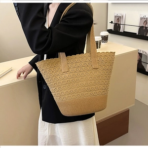 Detail of a large beige woven tote bag showing the intricate hollow-out crochet pattern