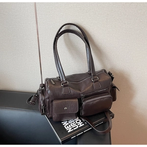 Détail du sac bandoulière vintage marron foncé avec plusieurs poches et grain de litchi