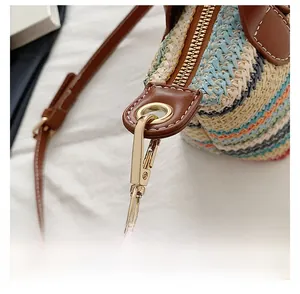 Macro shot of metal zipper and gold hardware hooks on a woven mini handbag