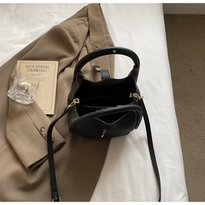Vue de dessus du sac à main en cuir noir grainé montrant l'intérieur et les poignées