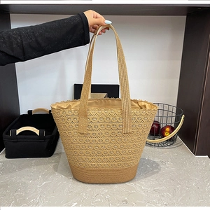 Detail of hollow woven pattern and fiber texture on a large straw beach tote bag