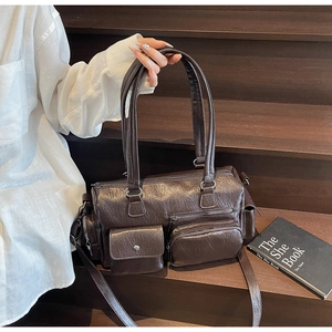 Détail de la texture cuir vintage marron et design multipoche avec zip du sac bandoulière