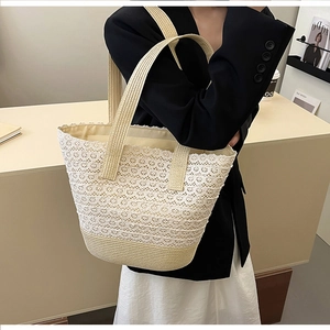 Detailed close-up of ivory lace hollow design and straw woven base on large tote bag