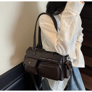 Détail du sac bandoulière marron foncé texturé litchi avec de multiples poches zippées