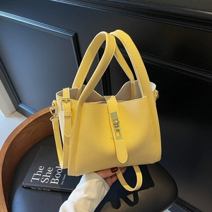 Pale yellow lychee grain leather bucket bag with top handles and adjustable strap