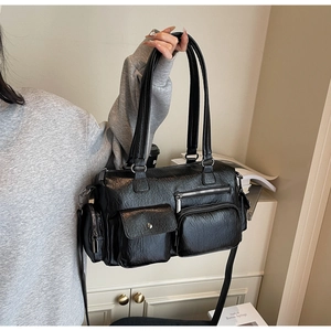 Détail du sac messager noir en cuir grainé avec plusieurs poches et finitions argentées