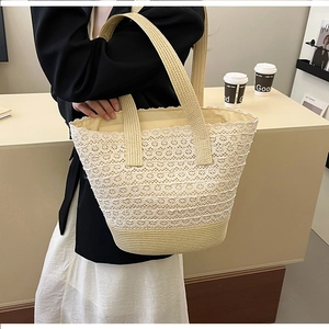 Close-up of beach woven tote featuring delicate white lace floral overlay and sturdy handles