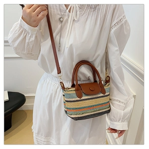 Detail of colorful striped woven crossbody bag with brown leather strap and snap button closure