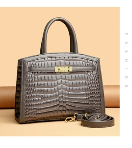 Detailed macro shot of the glossy crocodile-embossed texture and golden hardware on the handbag