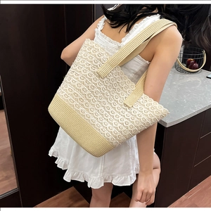 Detail of floral lace cutout pattern and woven texture on this large beige tote bag
