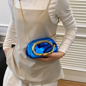 Détail de pochette bleu électrique métallisé avec poignée dorée et bandoulière chaîne